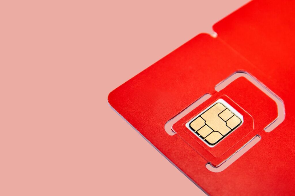 Cartão vermelho com chip de celular visto de perto.